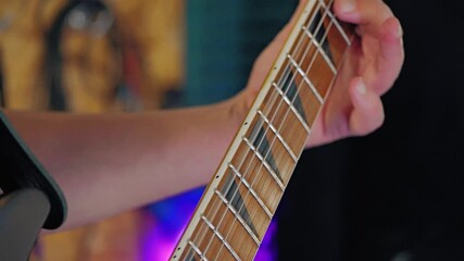 Close-up of vibrating sixth string of electric guitar and finger pressing on strings. Slow motion. Bright blurred background. Guitarist playing in studio - Powered by Adobe