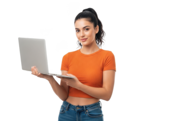 Young woman in orange top and blue jeans holding a silver laptop with a confident smile against a black background