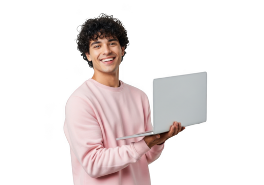 Young man with curly dark hair wearing a pink sweatshirt smiles while holding a silver laptop computer against a black background - Powered by Adobe