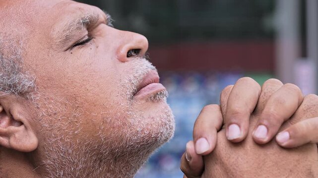 Elderly Man Praying With Hands United And Head Tilted Toward The Sky In Moment Of Deep Spiritual Reflection