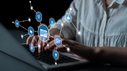 A woman is engaged with a laptop, surrounded by digital icons that symbolize connectivity and social media. This image represents the fusion of technology and marketing strategy. Tessel