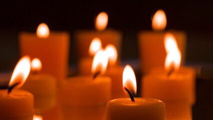 Warm glow of numerous candles illuminating a dimly lit space during a peaceful evening gathering.