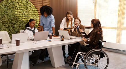Inclusive diverse business team working together, woman in wheelchair at office meeting