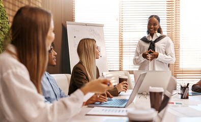 Business meeting with diverse team and woman in wheelchair presenting
