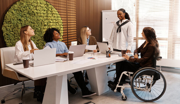 Diverse business team in meeting with disabled coworker - Powered by Adobe