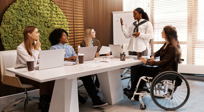 Diverse business team in meeting with disabled coworker