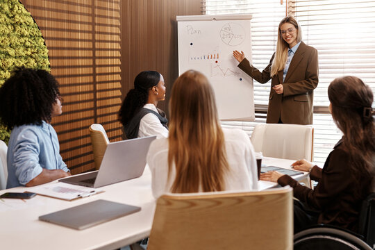 Diverse team listening to business presentation in modern office