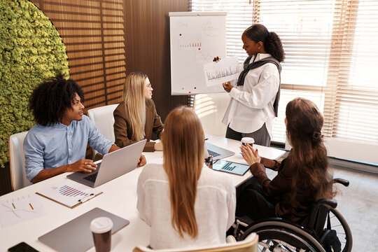Businesswoman presenting graph to diverse team during office meeting