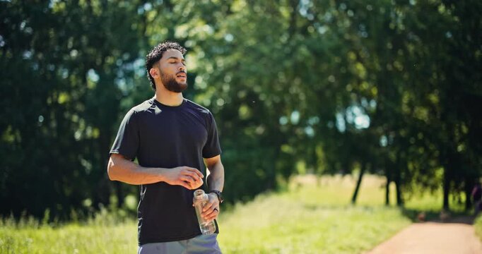 Fitness, man or drink water in nature with break for cooling hydration, check smart watch or wellness. Bokeh, person outdoor or beverage with tech for exercise recovery, electrolytes or step counter.