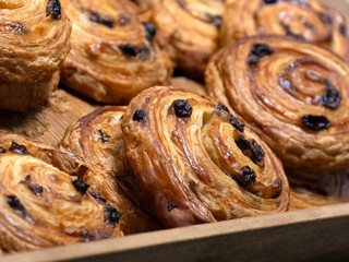 Pain Aux Raisins French pastries on a wooden tray at a bakery