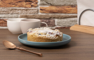 Delicious baked dessert served on a plate with coffee cups on a wooden table in a cozy setting