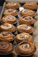 Closeup of Cinnamon buns on a wooden tray at a bakery