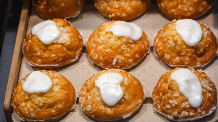Iced lemon Muffins on wooden tray at a bakery