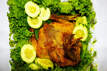 Whole Fried Chicken with Fresh Lettuce and Cucumber Garnish