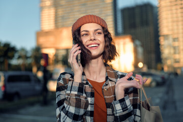 woman phone smile shopping in urban sunlight, casual portrait capturing authenticity and candid lifestyle with golden hour glow, mindful living vibe and emotional storytelling in city