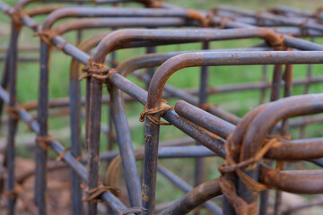 A close-up view of a rust-textured steel rebar frame used for house foundation construction,...