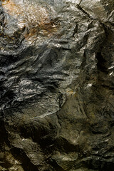 Textura de agua oscura en movimiento con reflejos brillantes, en el Cañón del río Santo Domingo, El Carmen de Viboral, Antioquia, Colombia. Fondo abstracto, dramático y orgánico.