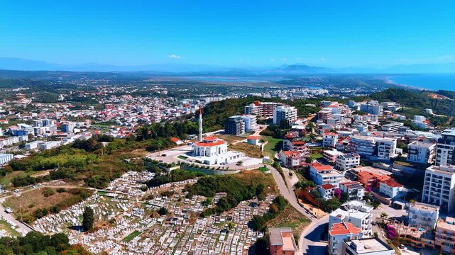 Approaching the mosque on top of the mountain surrounded by the beautiful houses. Aerial view on the city in Montenegro at the shore of the Adriatic Sea.