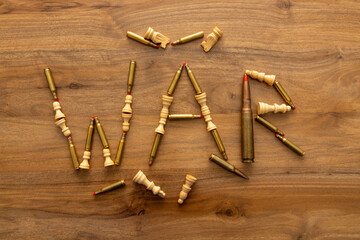 Chess pieces and blank cartridges form the word WAR on a wooden background, blending strategy with conflict symbolism and highlighting global tension, uncertainty and the growing sense of instability.