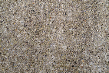 Concrete texture closeup with rough gray surface and embedded stones for background use in design