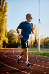 Full length of mature sportsman jogging in park.