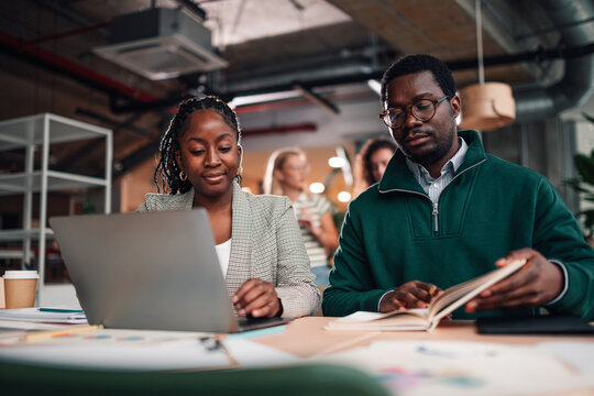 Black professionals collaborating during office meeting - Powered by Adobe