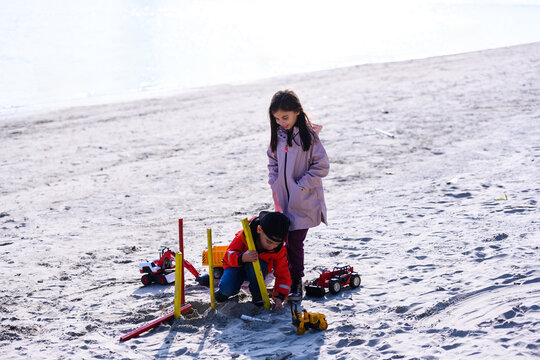 Children playing with sand toys on beach