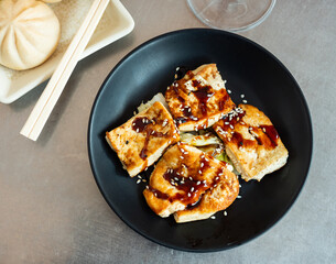 Fried tofu with soy sauce and spices, cooked according to a Chinese recipe. Delicious Asian dish for lunch