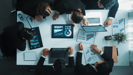 Top view of smart business people brainstorm marketing idea at meeting table while compare stock market investment data between laptop and tablet. Business team planning financial plan. Directorate. - Powered by Adobe
