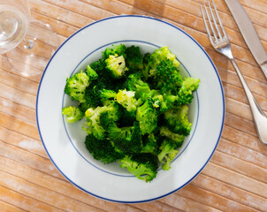 Plate of freshly roasted green broccoli for healthy vegetarian lunch. Diet food