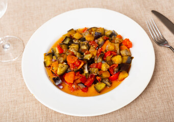 Appetizing vegetable stew in the Mediterranean style, made with natural ingredients. Stewed farm vegetables on a white plate