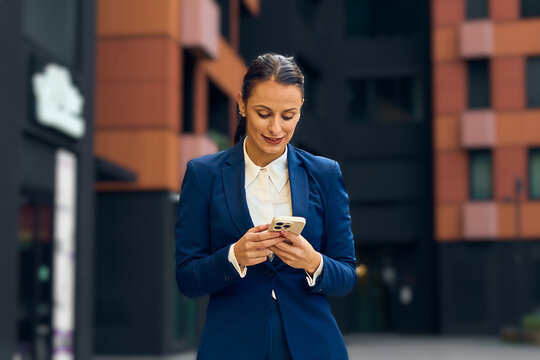 Professional Real Estate Agent in Blue Suit Using Phone in Modern Brand New Urban Area