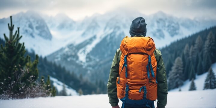 Hiker with backpack exploring snow-covered mountain landscape in winter