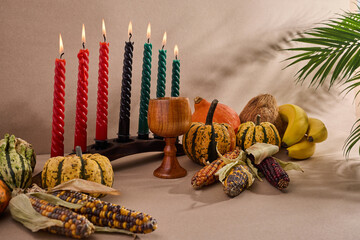 Festive Kwanzaa Setting. A warm Kwanzaa scene with a kinara, fruits, and vegetables