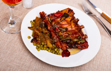 Pork ribs with peas and vegetables closeup