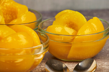 Half-cut peaches, canned preserve. Close-up photograph with copy space on a rustic background.