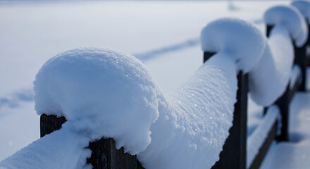 A wooden fence covered with a thick layer of white snow, representing winter landscape, cold weather, or seasonal change, perfect for nature concepts