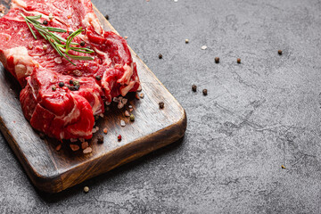 Raw beef meat on a wooden cutting board