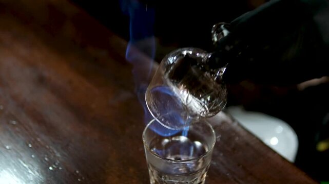 Bartender sets fire to cocktail, burning cinnamon in alcohol drink, per second, barman makes drink. High quality 4k footage