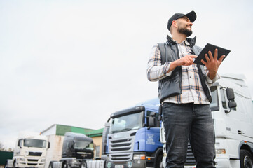 Truck driver using digital tablet overseeing logistics operation