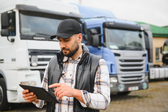 Truck driver checking logistics data on tablet - Powered by Adobe