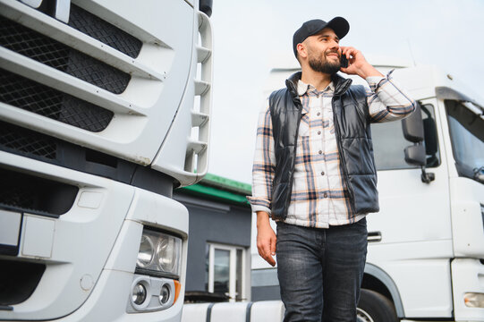 Fototapeta Truck driver talking on phone near lorry transportation