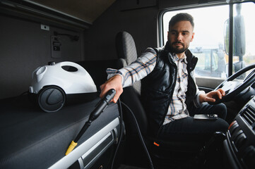 Truck driver cleaning cabin interior with steam cleaner