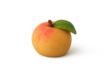 Marzipan fruit in peach shape with a green leaf