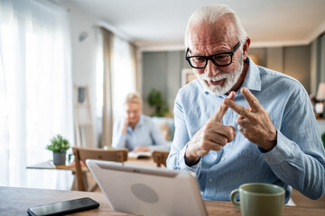 Senior man using sign language during video call