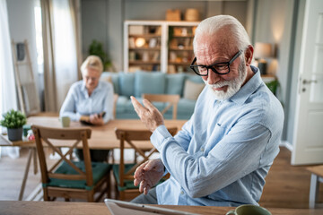 Senior man using tablet for video call at home
