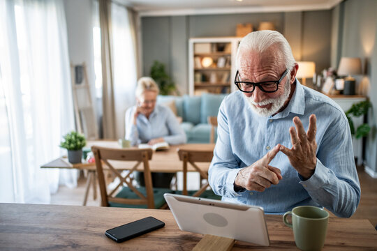 Senior man using sign language during video call - Powered by Adobe