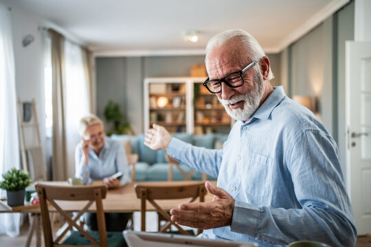 Senior man having video call with wife in background - Powered by Adobe