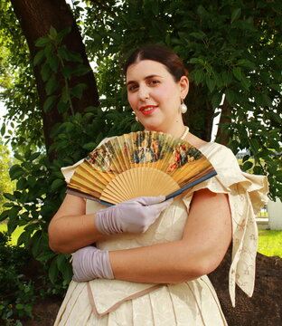 Young woman in the park with a replica of antique fan