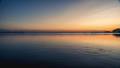 Obraz premium Calm Ocean Reflecting Golden Sunset Sky with Distant City Skyline and Gentle Waves on Sandy Shore